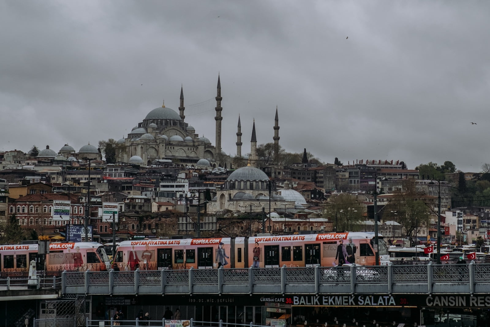 a train traveling over a bridge next to a city